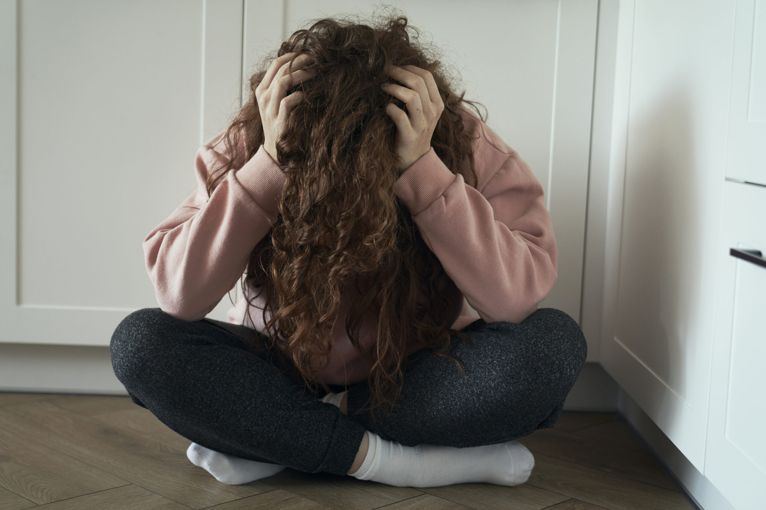 woman having a panic attack on floor
